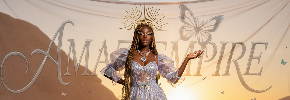 Woman in a glamorous dress standing in front of a desert backdrop with 'Ama Empire' branding.